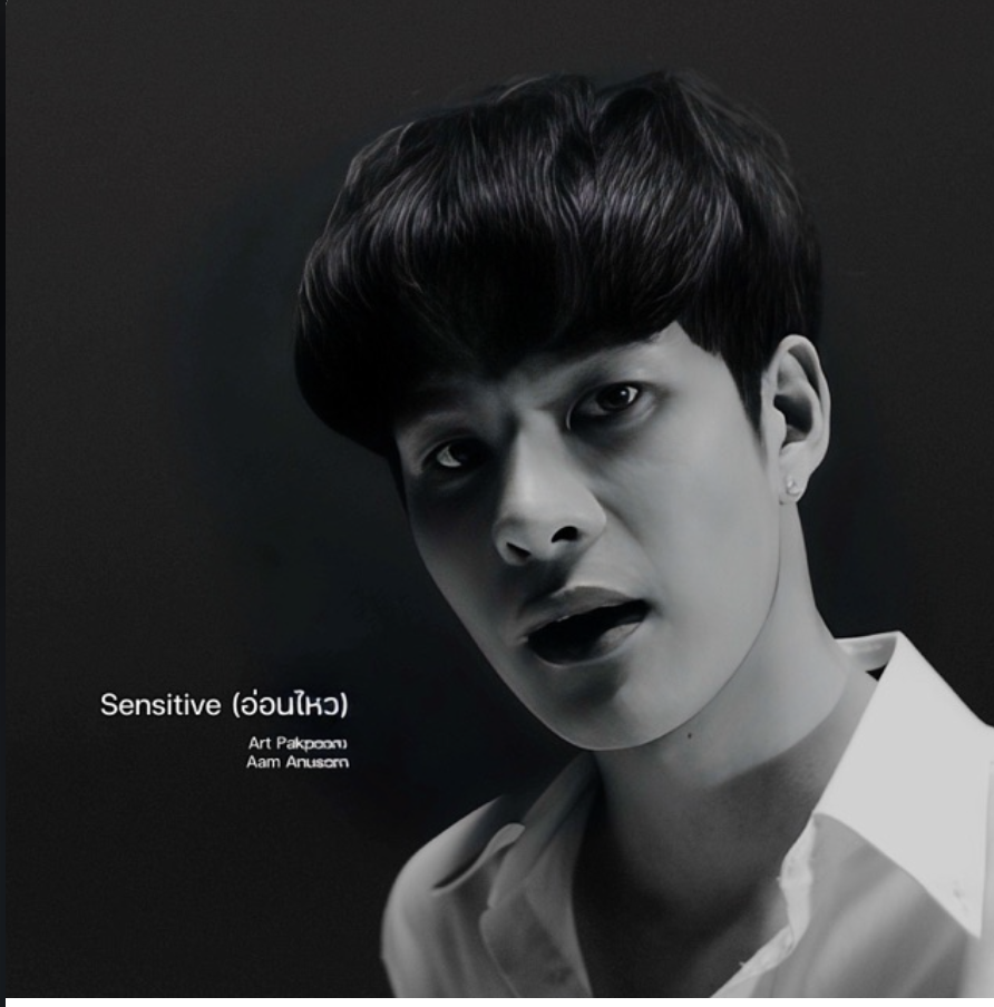 Black and white portrait of a young man with short dark hair, open mouth, and serious expression, wearing a collared shirt, against a dark background.