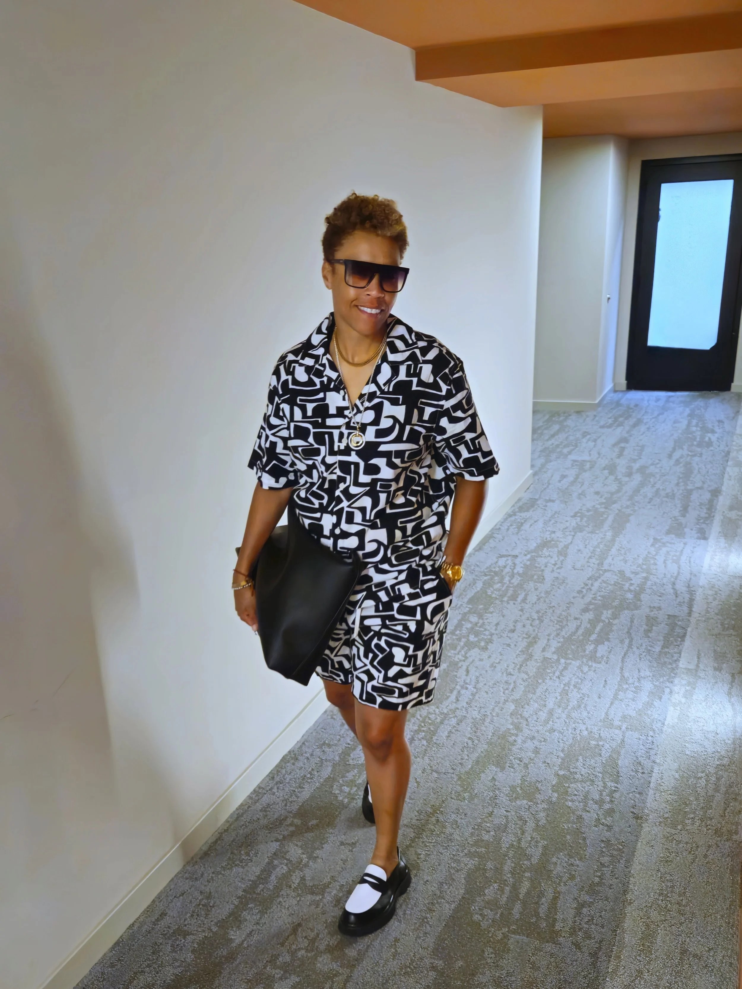 Fits before flags. Look 2 of 12.

Black and white is her uniform on the field. Today she&rsquo;s wearing it into the building. Same colors, her terms.

Here&rsquo;s the play:

1. The co-ord. Black and white abstract print, top and bottom. Same palett