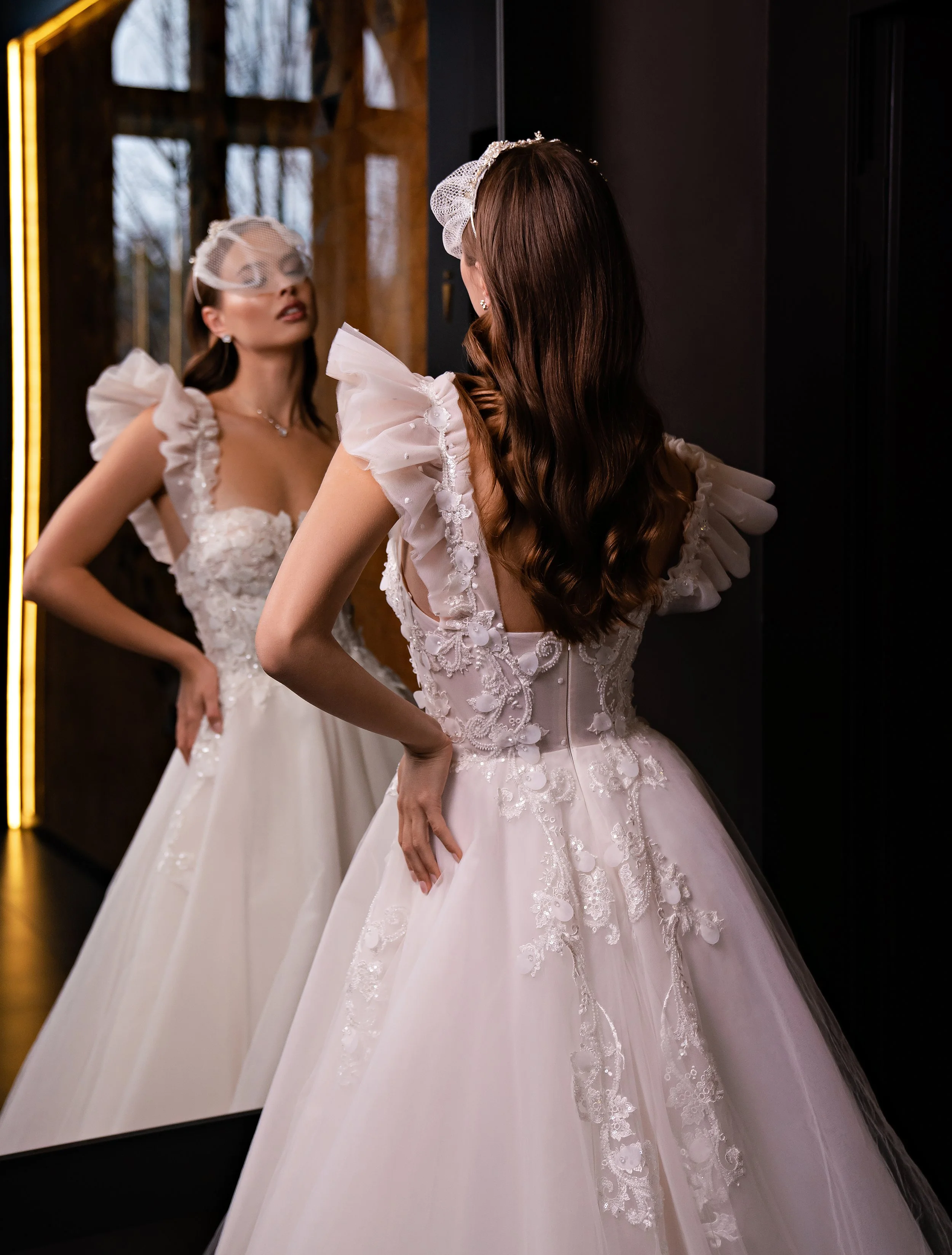 Femme en robe de mariage élégante se regardant dans un miroir.