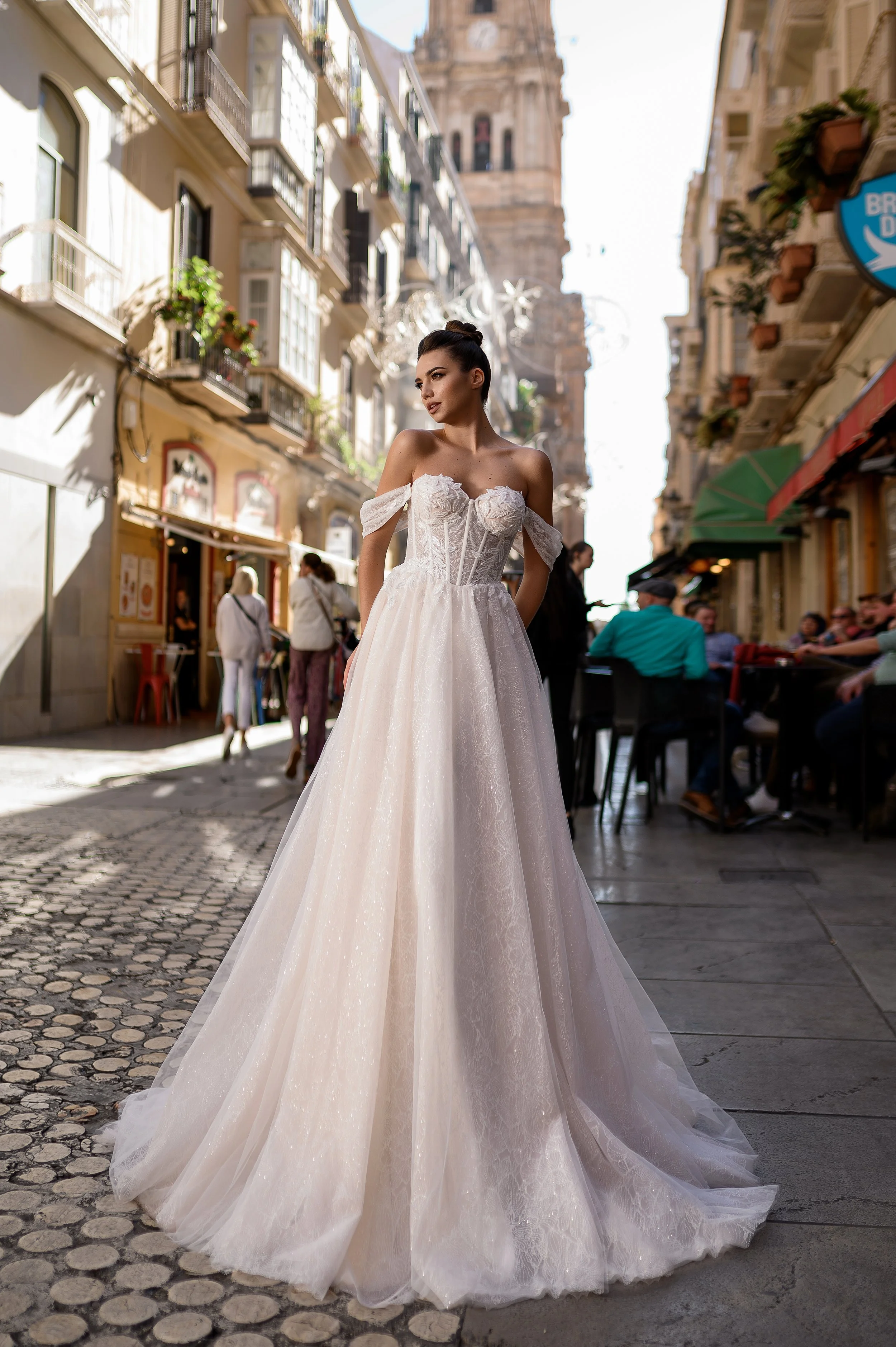 Femme portant une robe de mariée dans une rue urbaine bondée.