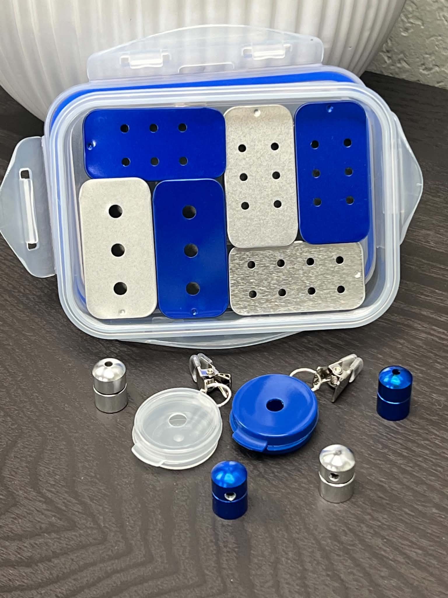 Blue and silver scent work kit with assorted scent work tins, hanging hides and Nano training vessels