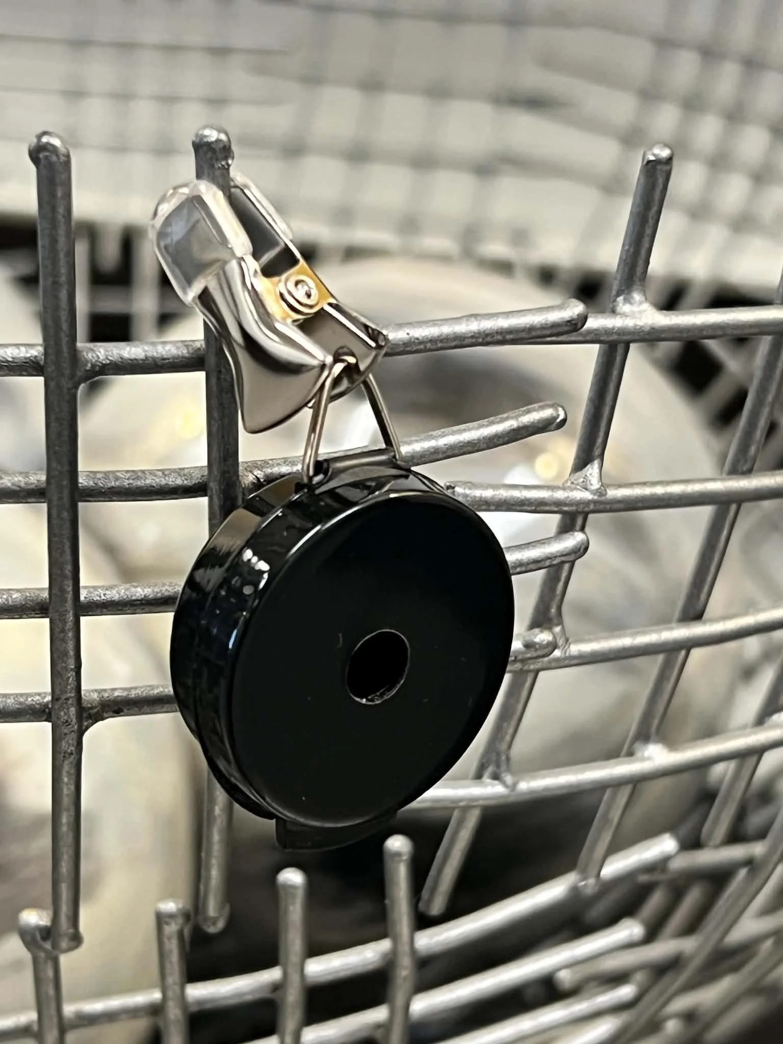 Hanging hide vessel suspended by a cord with multiple scent-access holes for canine nose work training.