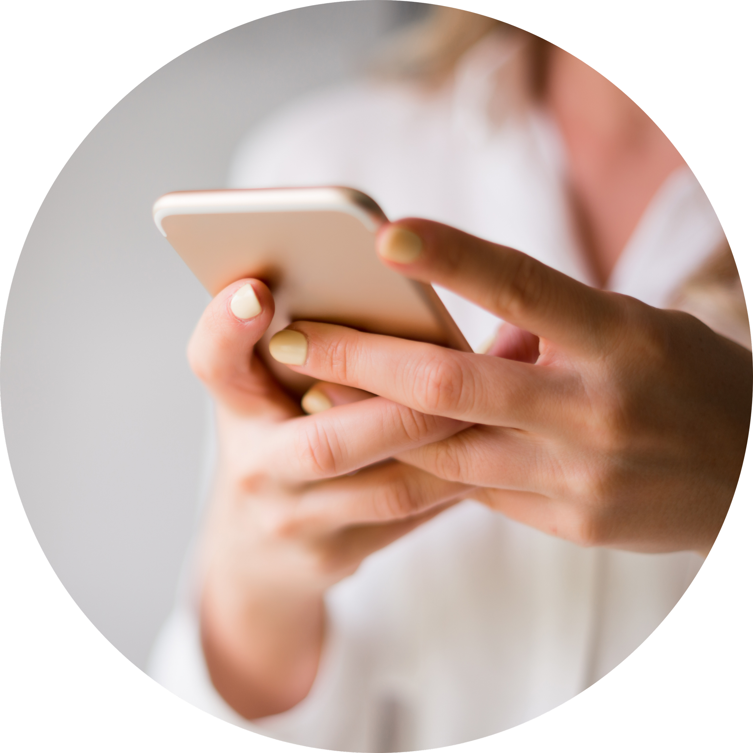 Person holding and looking at a smartphone with both hands, wearing a white shirt and painted nails.