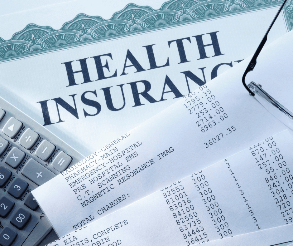 A medical bill or receipt, partially covering a healthcare insurance document, with a calculator nearby.
