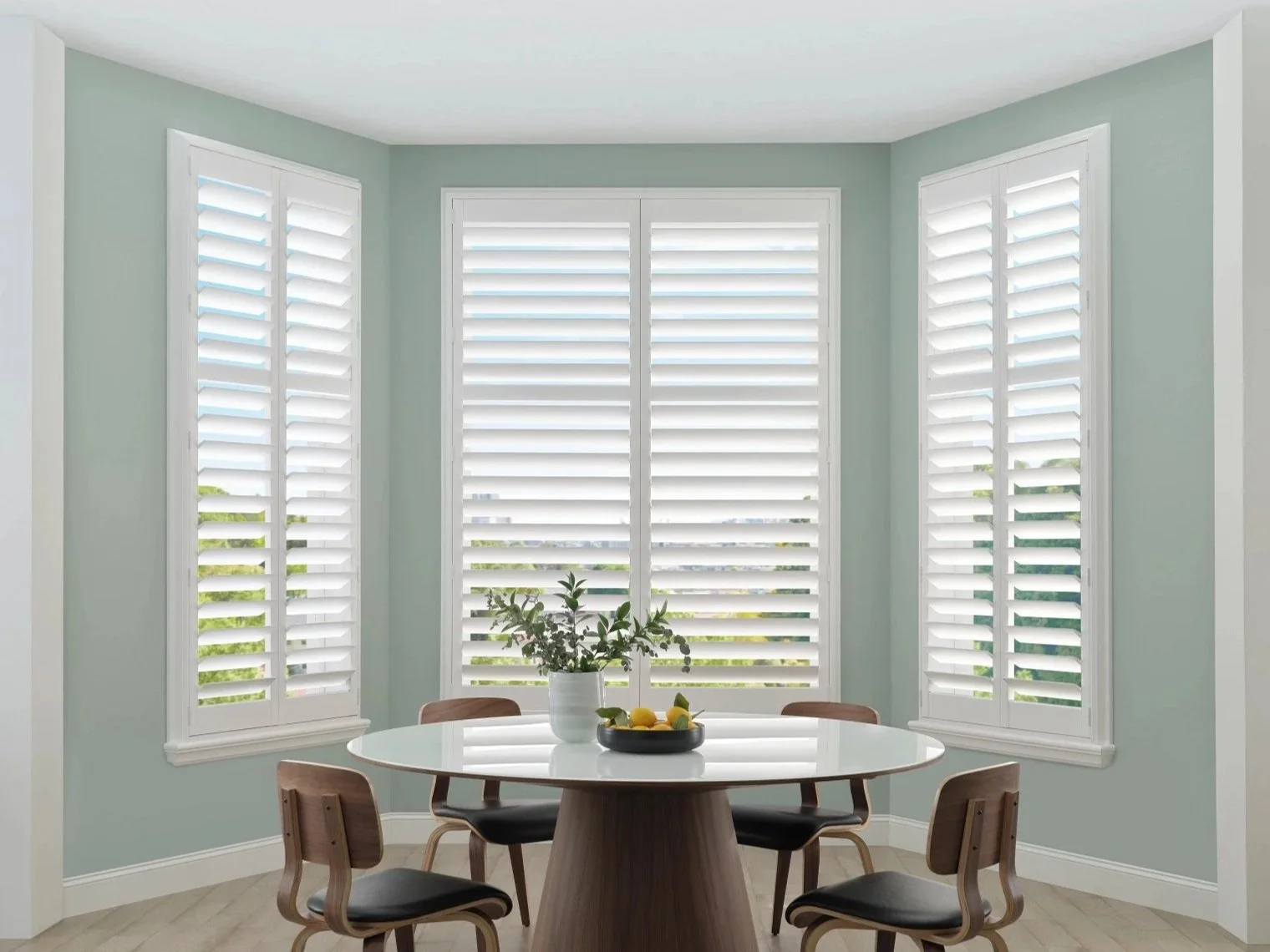 Three Hunter Douglas NewStyle® Shutters in a kitchen bay window setting.