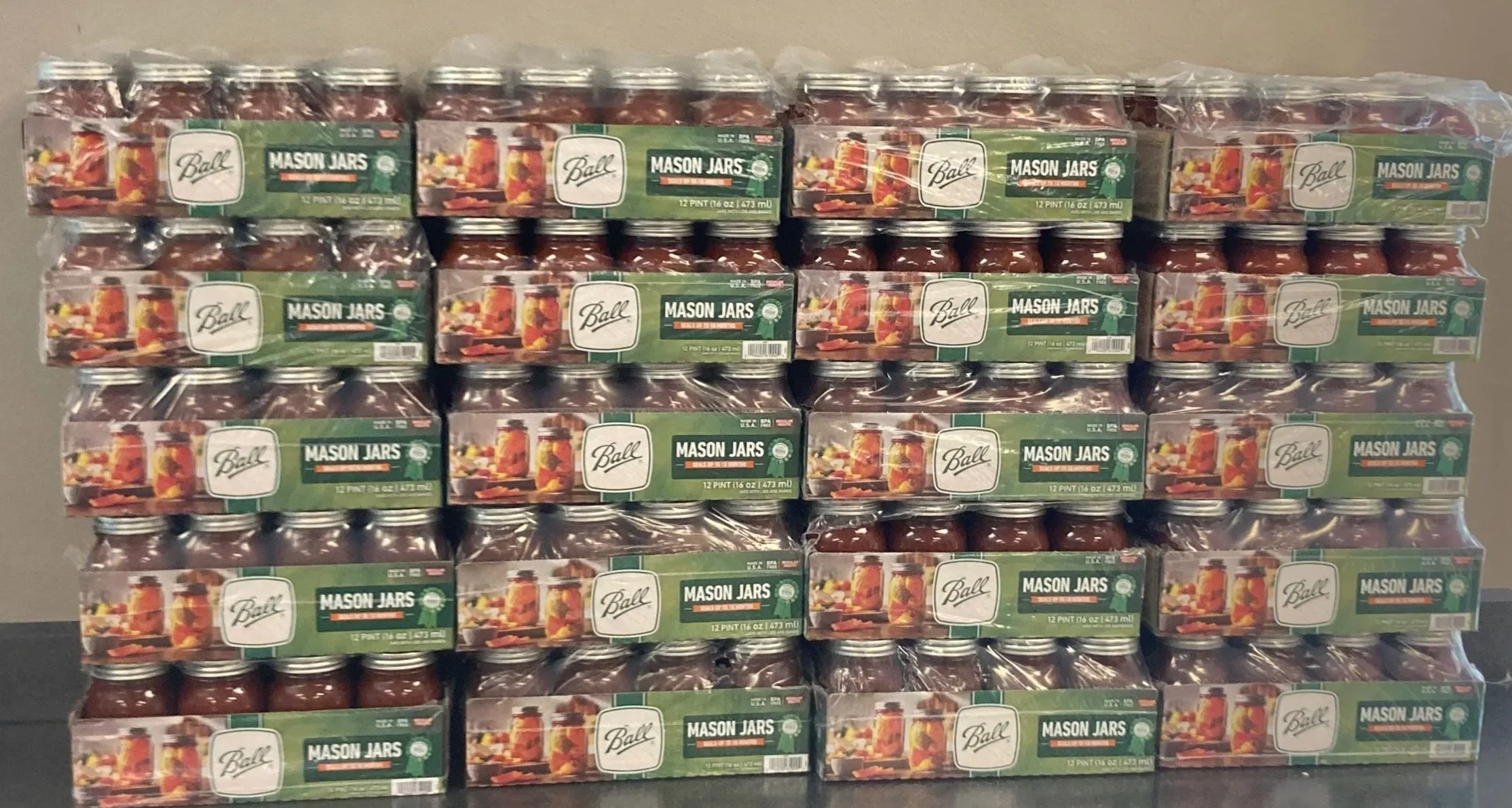 Stack of multiple boxes of Ball Mason Jars with jars inside, each box labeled '12 Pint'.