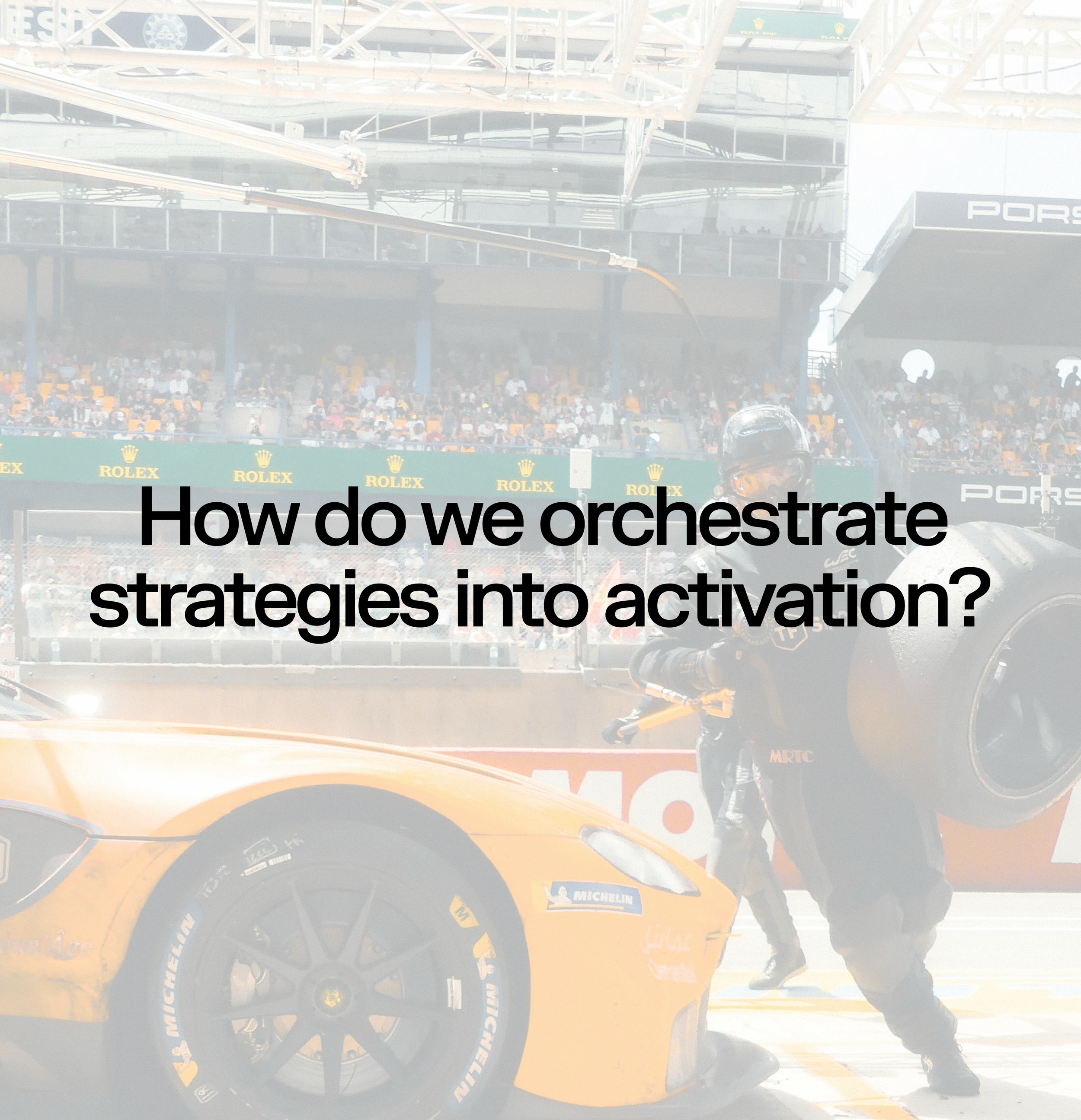 Race car pit stop with a mechanic holding a tire, at a racetrack with spectators in the stands, and the question 'How do we orchestrate strategies into activation?' overlaid.