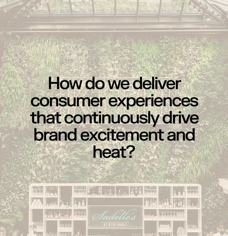 Text overlay on a green wall of lwith plants, reading: "How do we deliver consumer experiences that continuously drive brand excitement and heat?" in black font, with a bar or retail display below showing a logo for Sadelle's at Kith Paris.