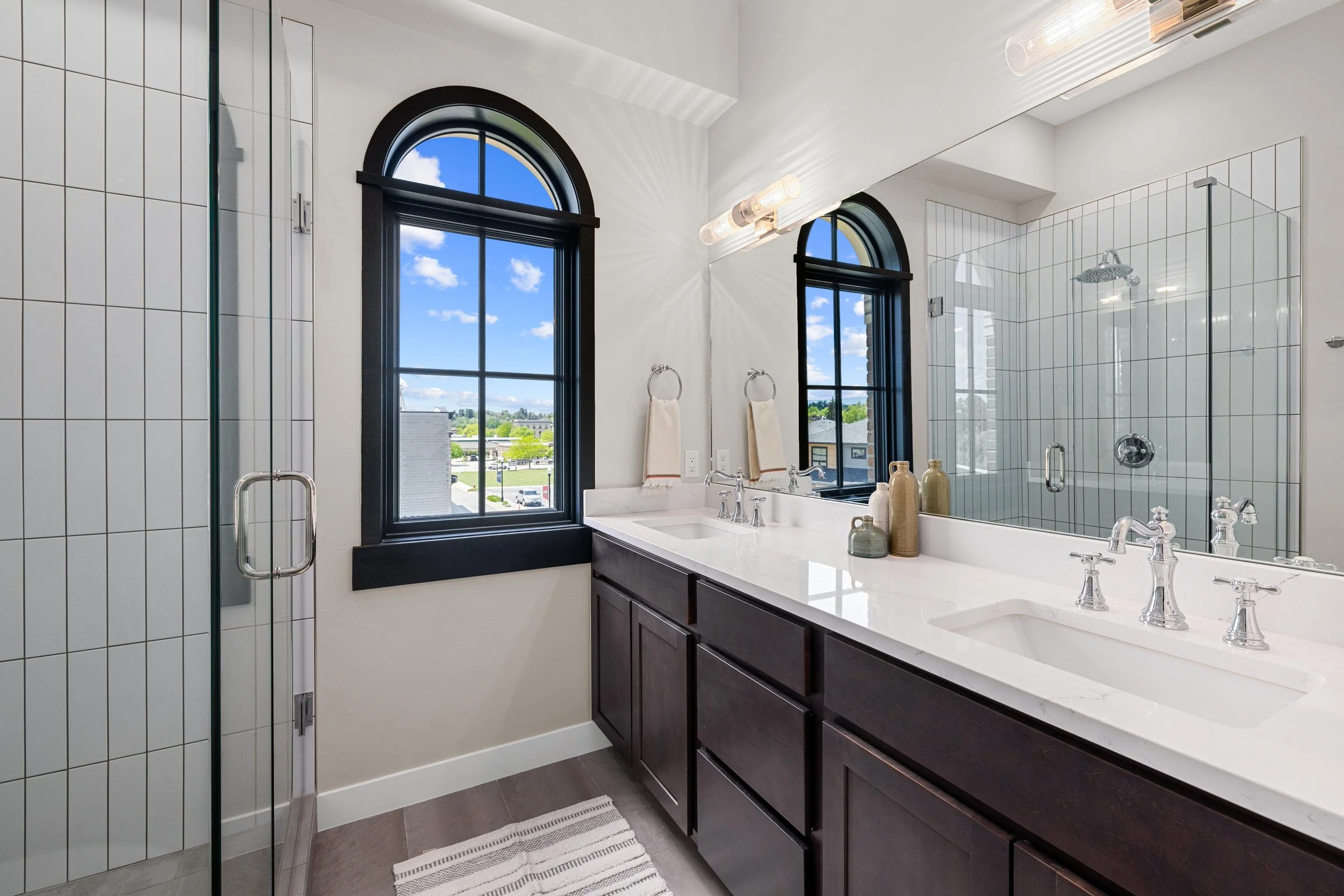 Modern staircase and laundry area inside an Ice Haus Condo for sale in Sheridan, WY, with wood steps, black railing, and built-in cabinetry.