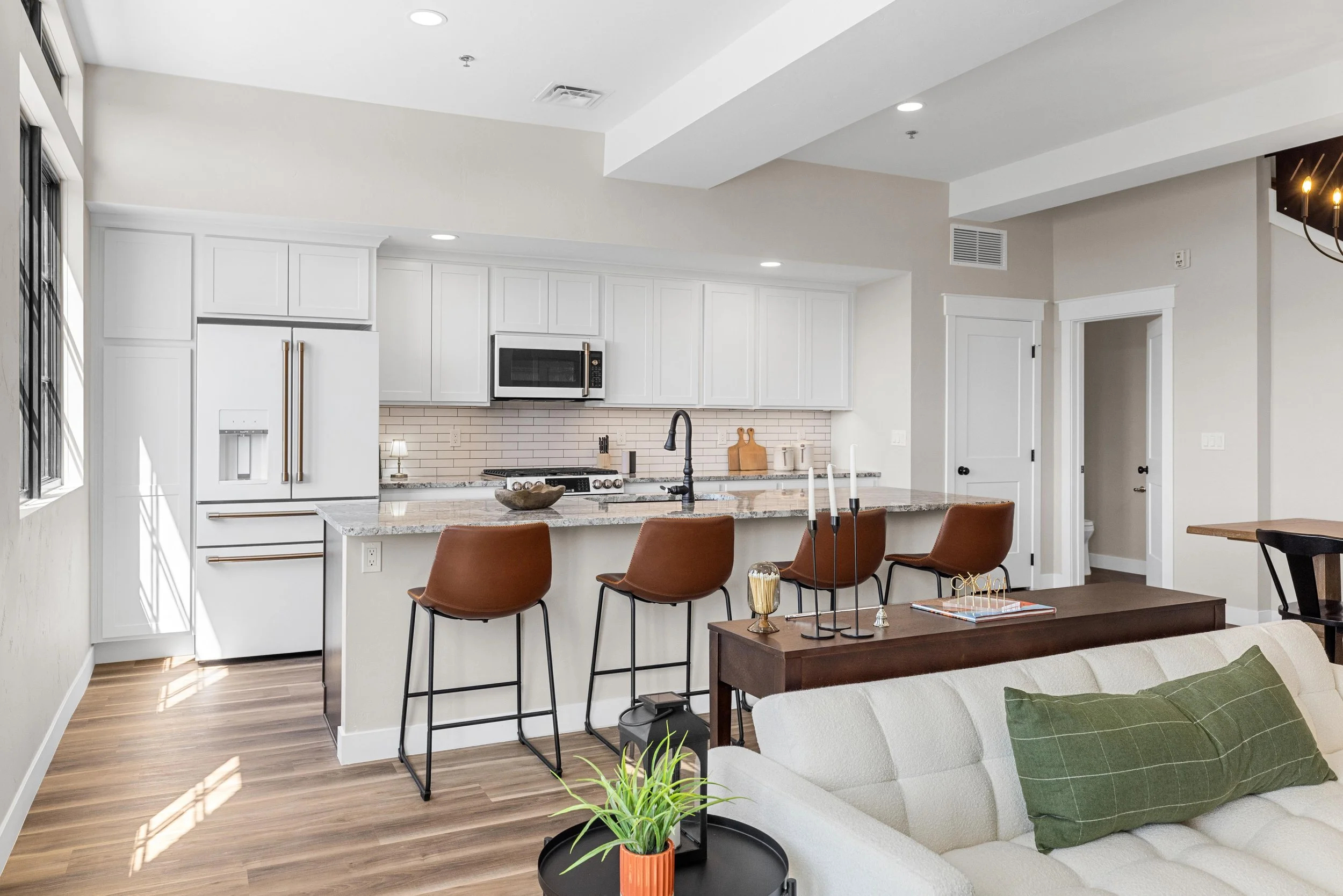 Open-concept living space inside an Ice Haus Condo for sale in Sheridan, Wyoming featuring modern kitchen, island seating, and bright contemporary design.
