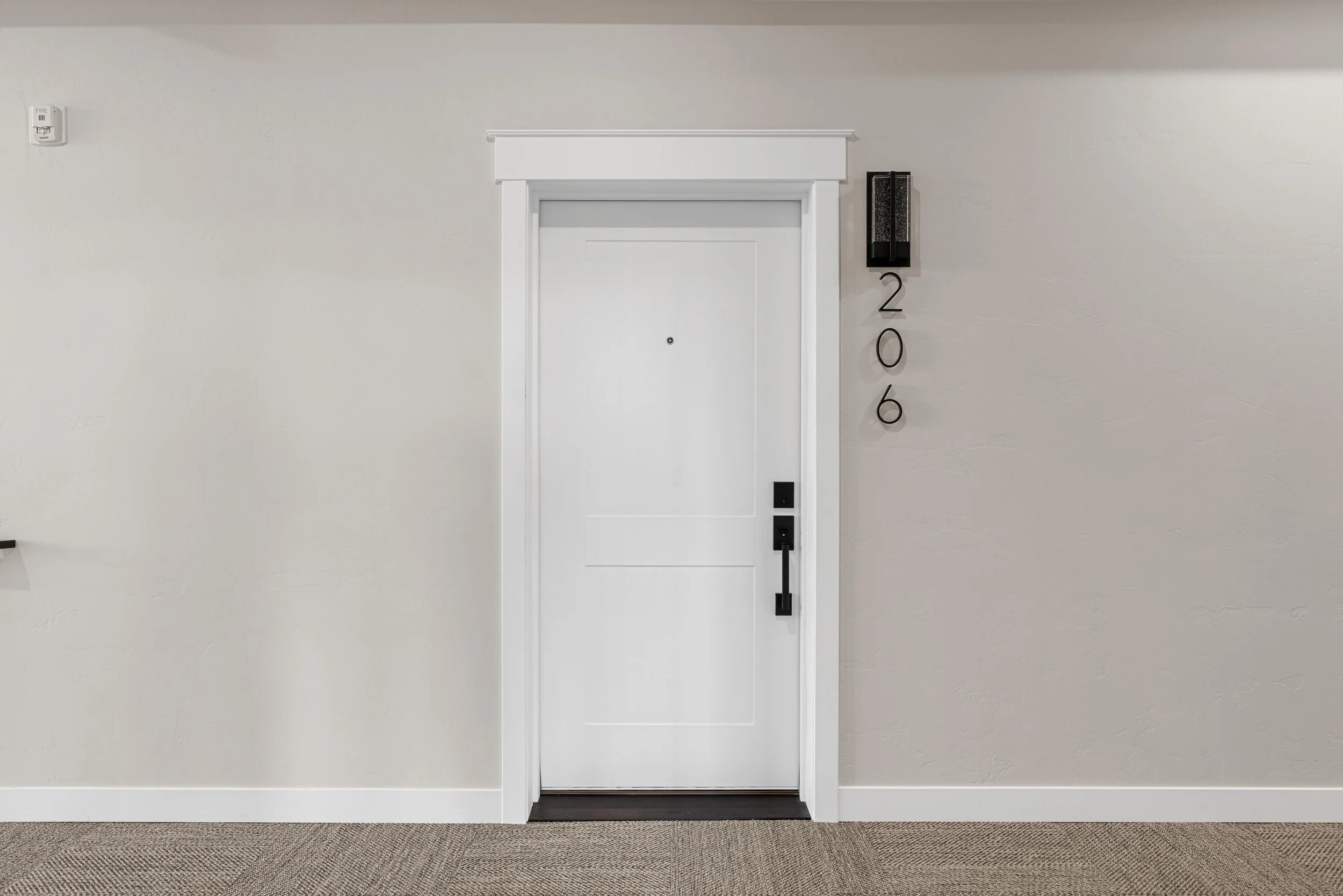 Private entry door to an Ice Haus Condo for sale in Sheridan, WY, featuring modern hardware and clean contemporary design.