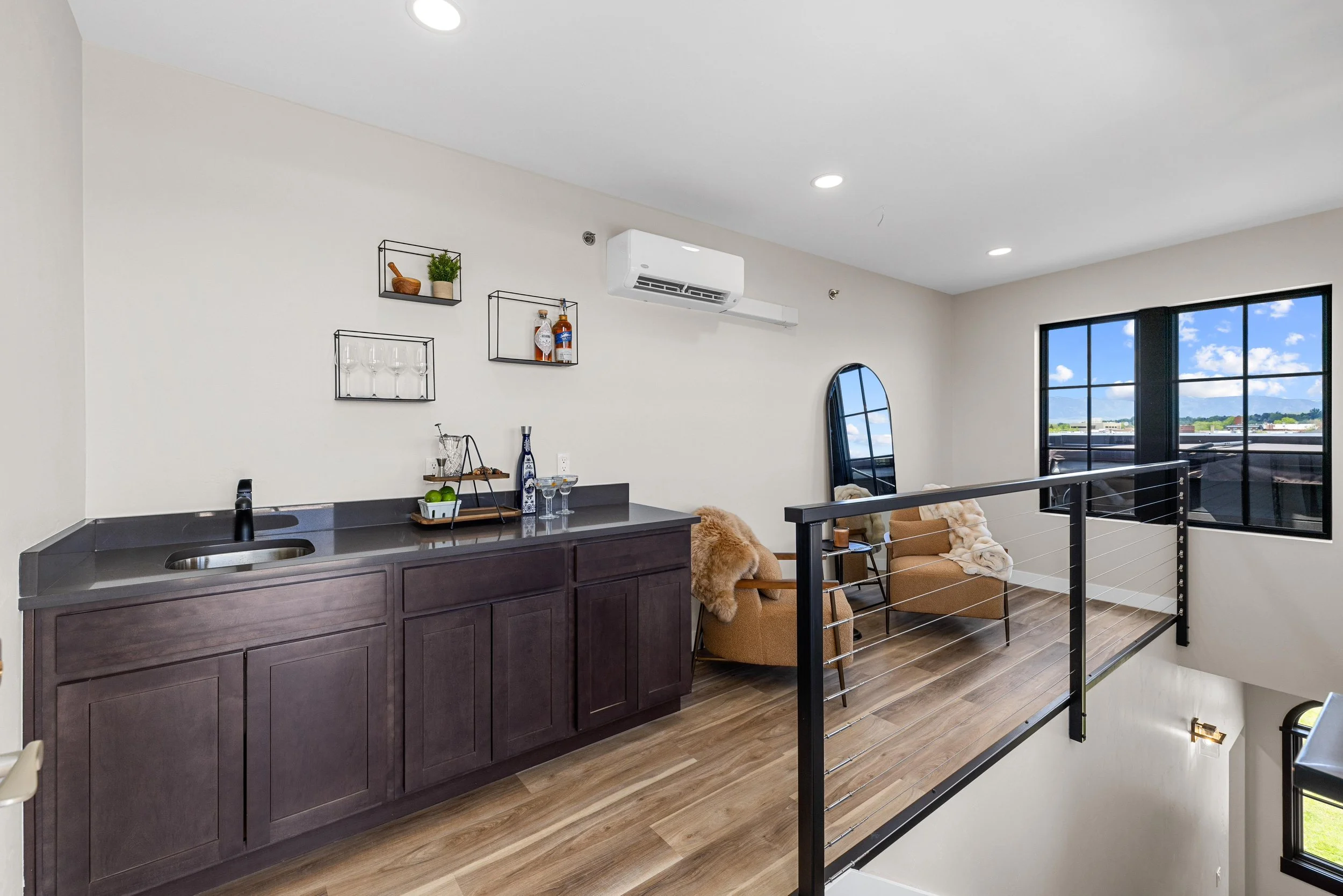 Loft living area inside an Ice Haus Condo for sale in Sheridan, Wyoming featuring seating space, large window views, built-in cabinetry, and modern design.