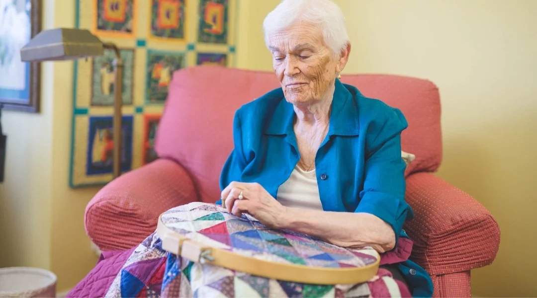 Senior woman hand quilting a panel