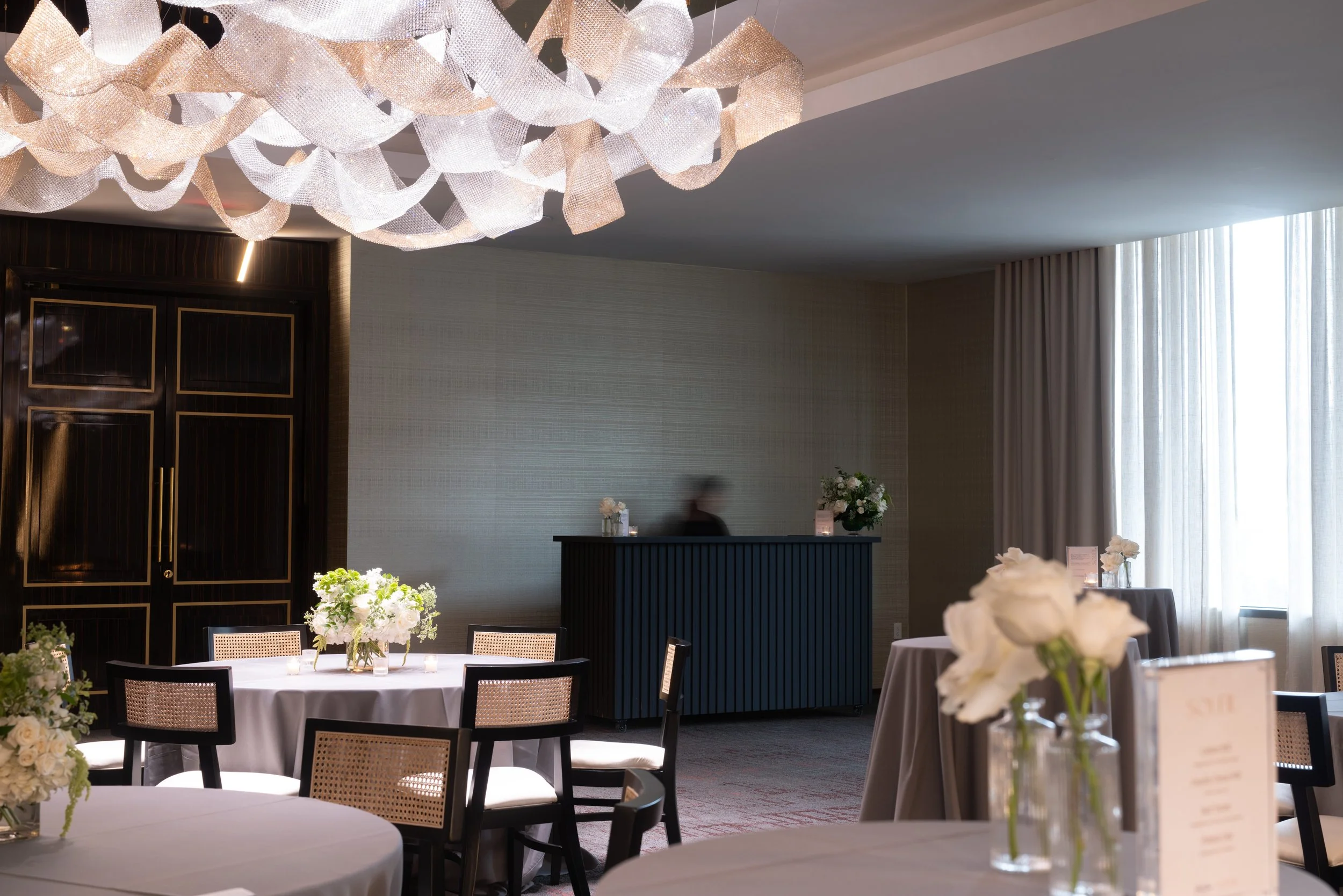 round tables with florals, cocktail tables, and satellite bar