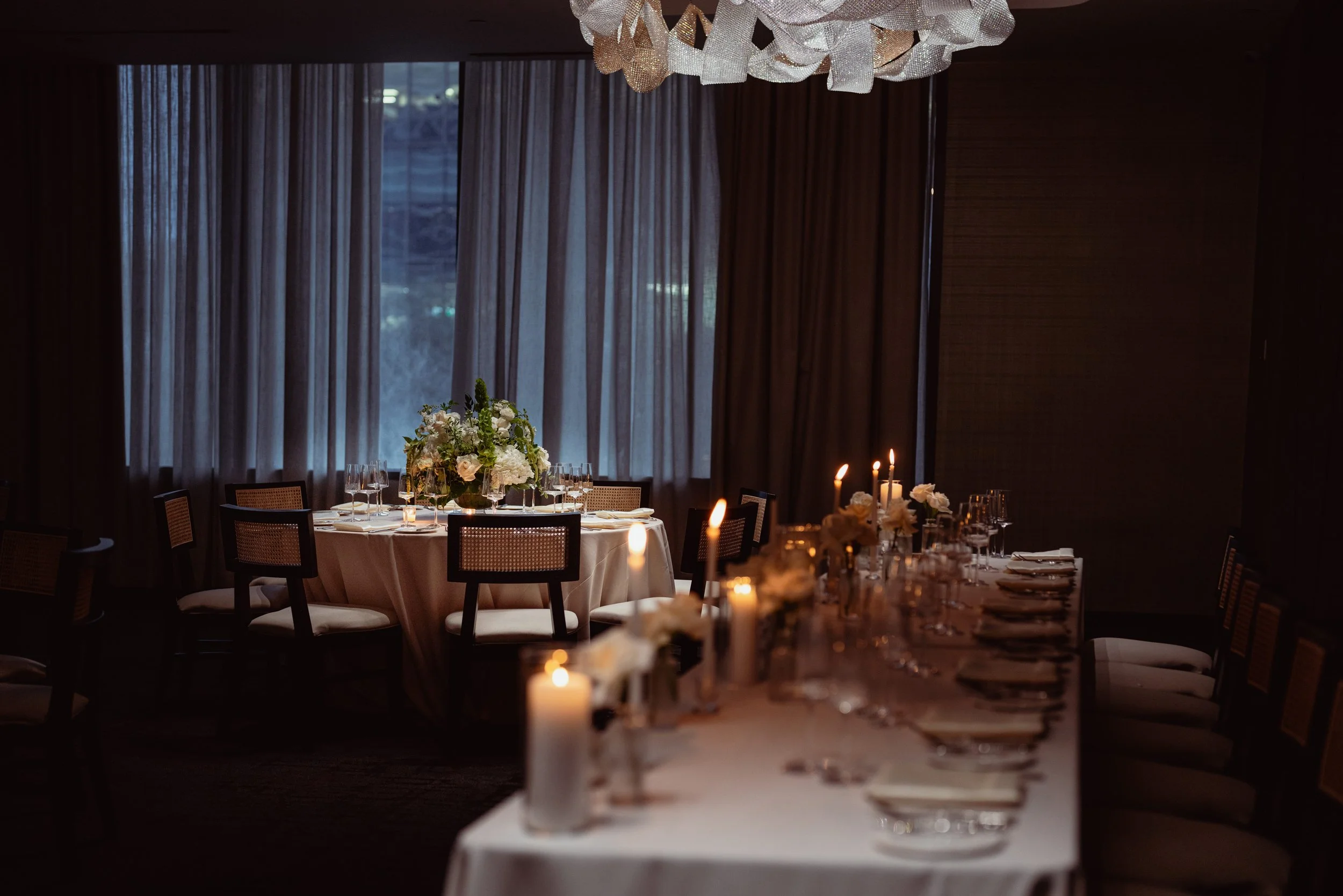 evening setting of one long table and round table with candles