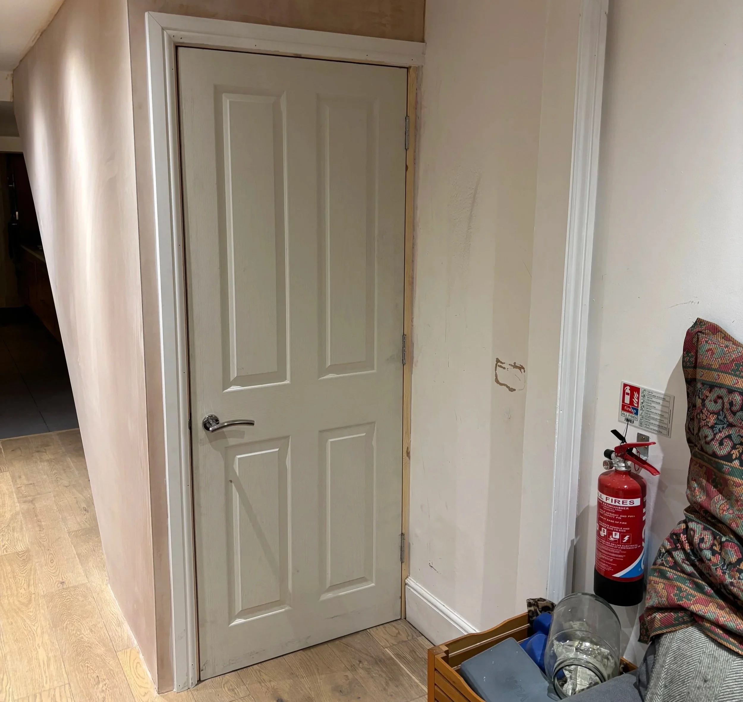 Wooden door in frame with fire extinguisher