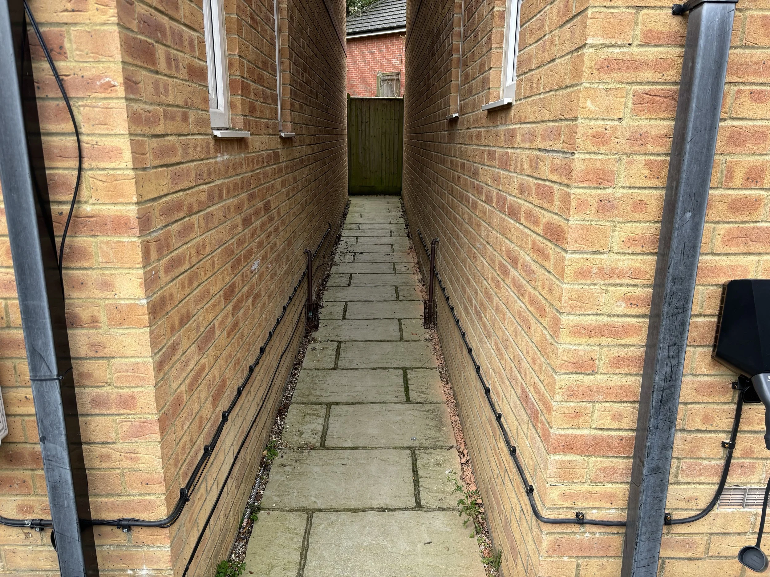 Bricked wall with black wires running along the bottom
