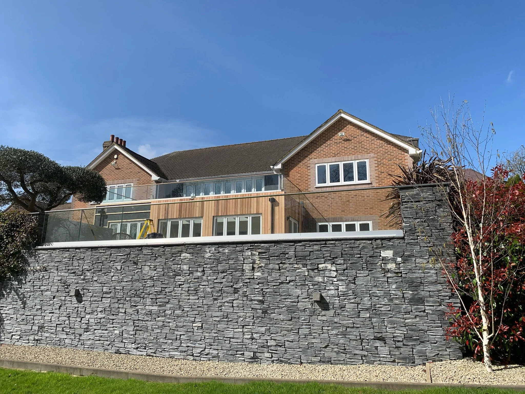 bricked building with grey slate balcony and glass balistrade