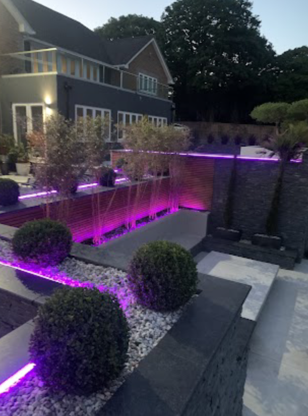 Modern garden with purple lighting around balcony