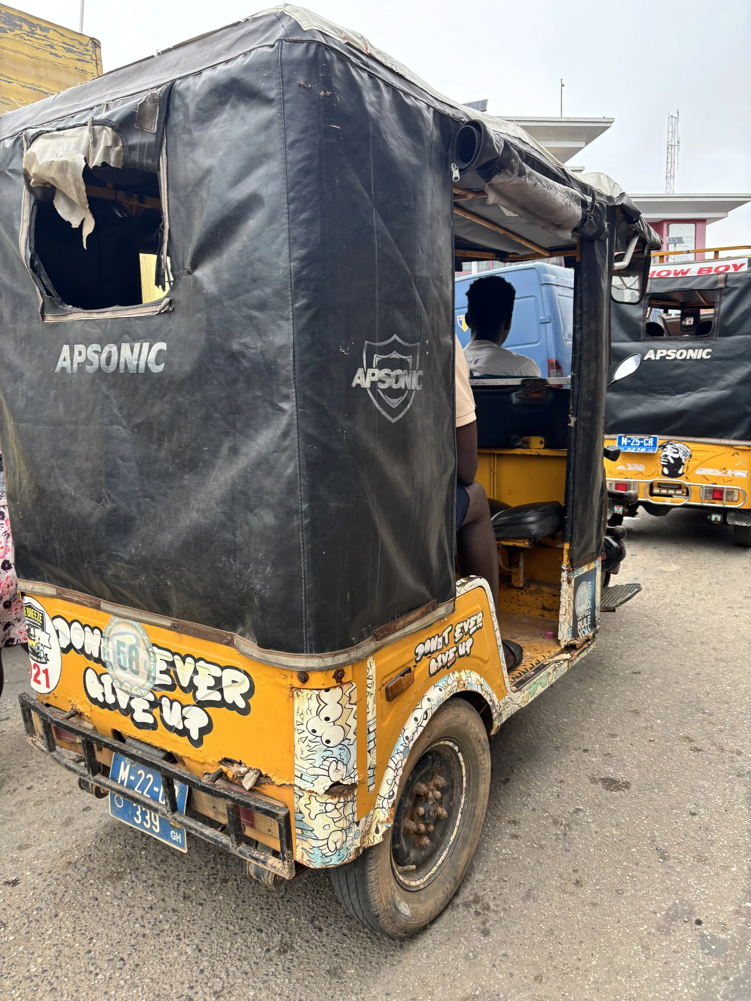Man driving a Pragya in a West African city