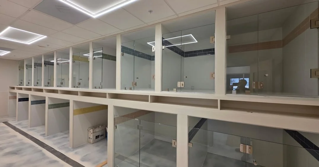 Tiled and glass display cases in a modern dog boarding area with glass doors and colored tile accents along tiled compartments. In "A Place To Paws" "luxury dog boarding" and "interactive doggy daycare" in Bluffton SC in the lowcountry