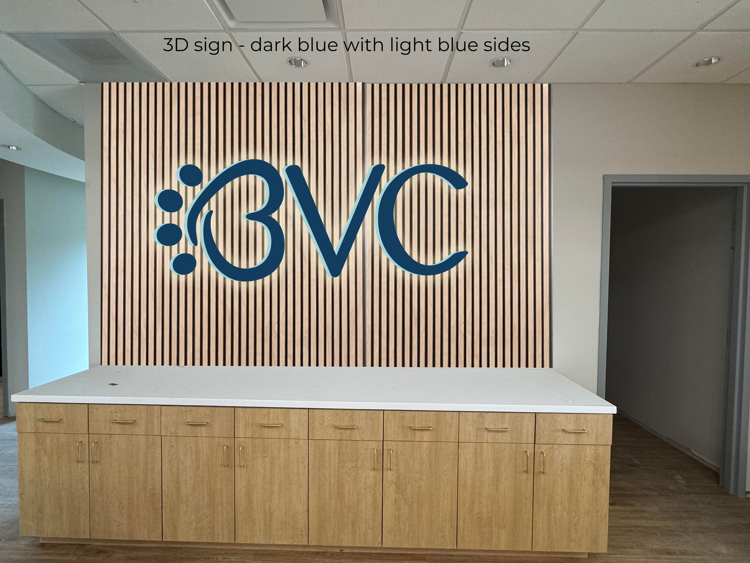 A reception area with a large wall display featuring the BVC logo, which includes a stylized blue paw "B", the text 'BVC' in bold blue letters, a wooden cabinet underneath, and a wooden slatted wall behind the logo. Buckwalter Vet Clinic in Bluffton