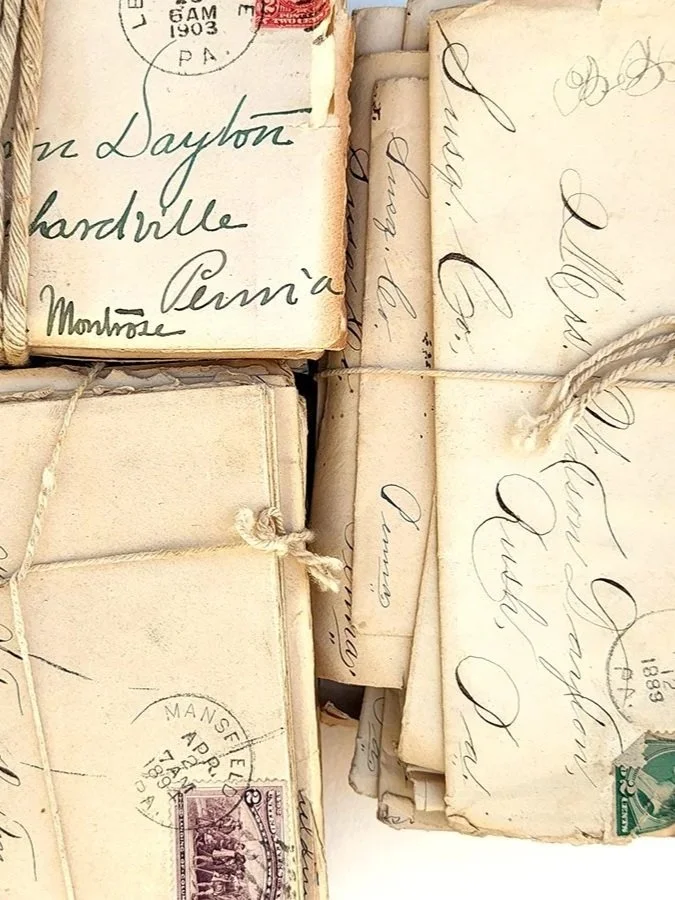 A collection of old, handwritten letters and envelopes with vintage postage stamps and postmarks.