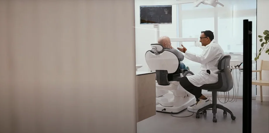 Arzt im Gespräch mit Patient in modern gestalteter Facharztpraxis mit durchdachter Innenarchitektur.