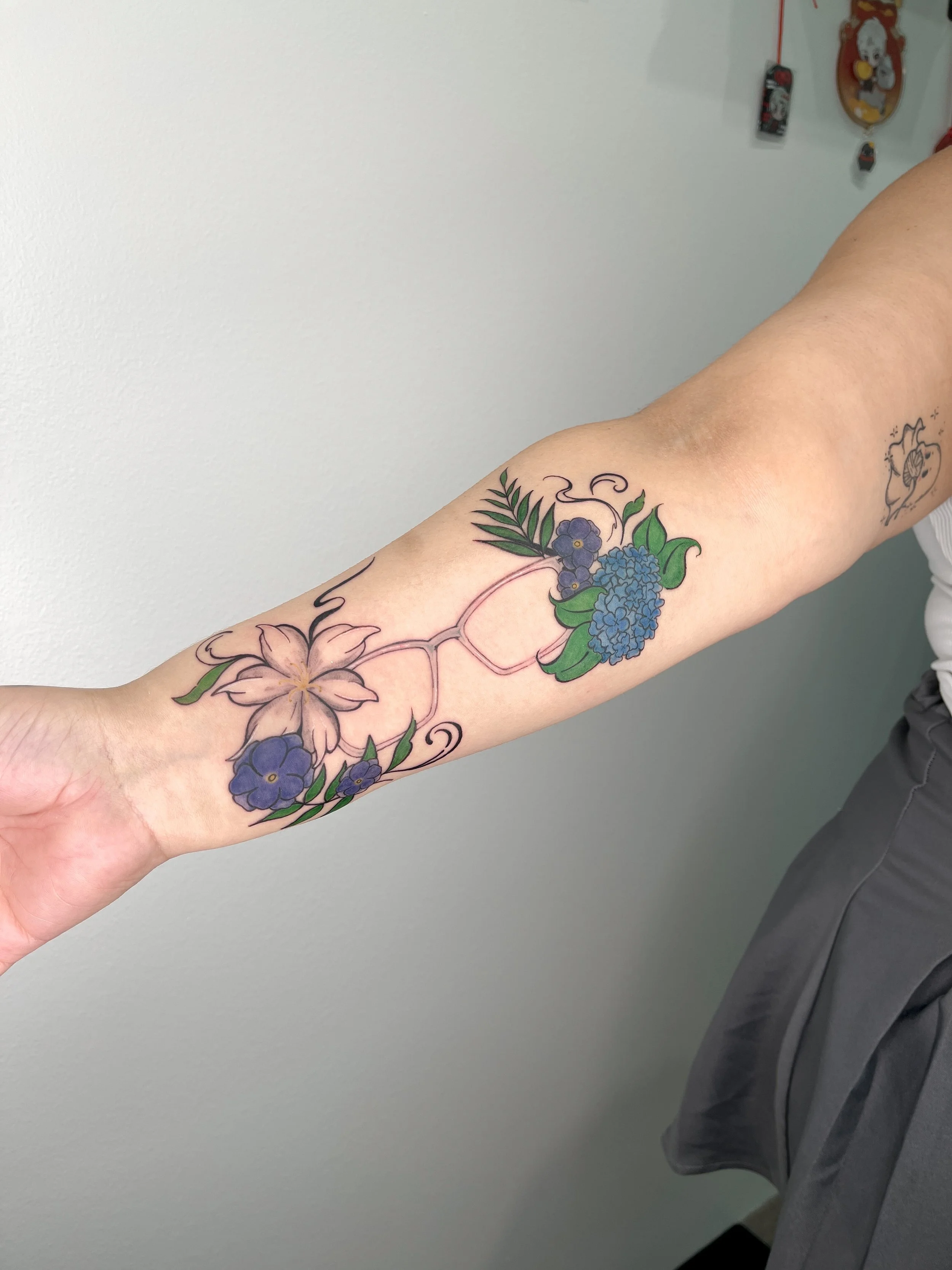 Client's memorial piece of her mother's glasses frames surrounded by her favorite flowers and plants.
