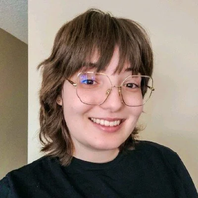 Joelle smiling in front of a neutral background.