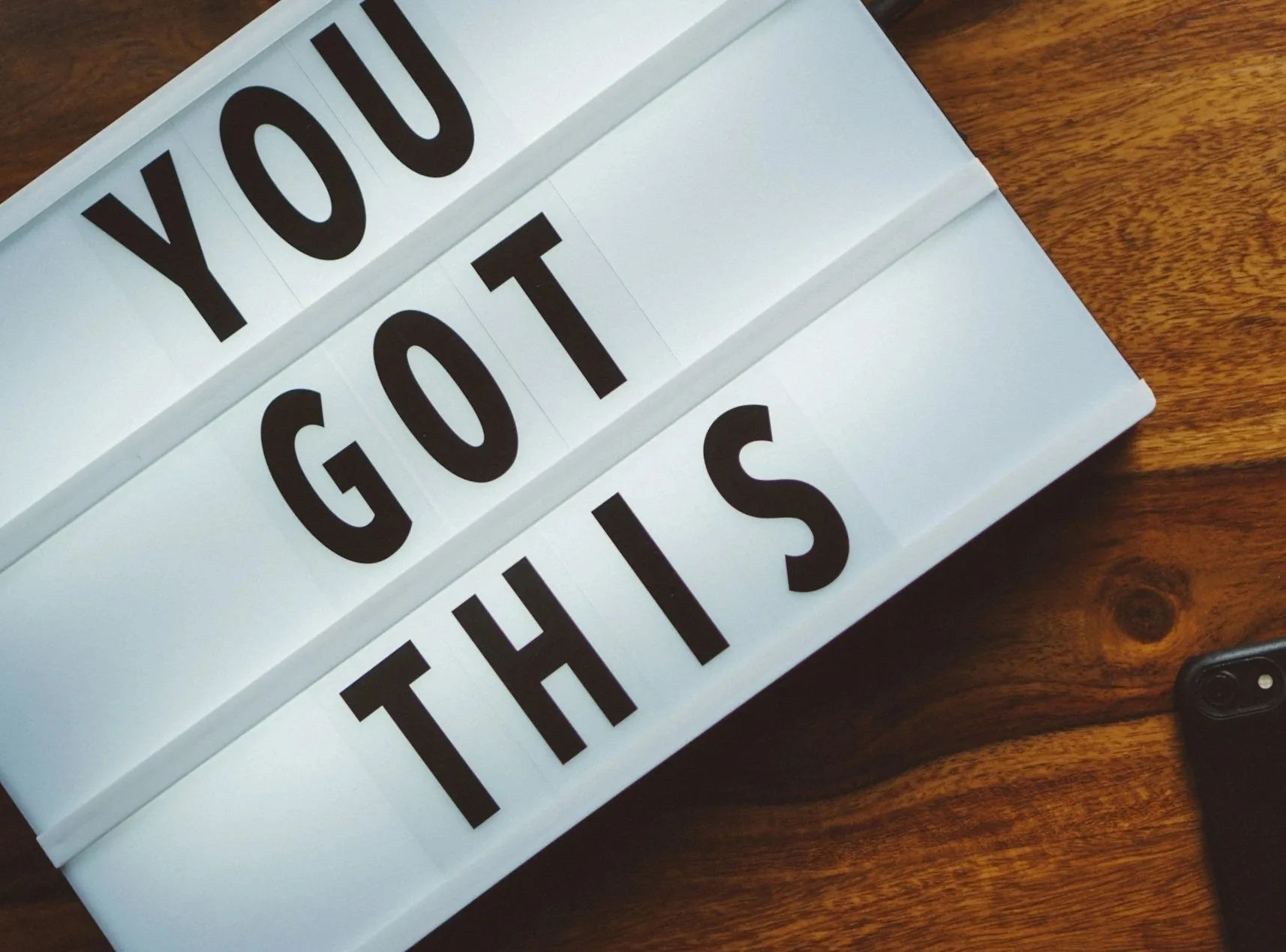 Lightbox with the words 'You Got This' displayed in black letters on white background, placed on a wooden surface.