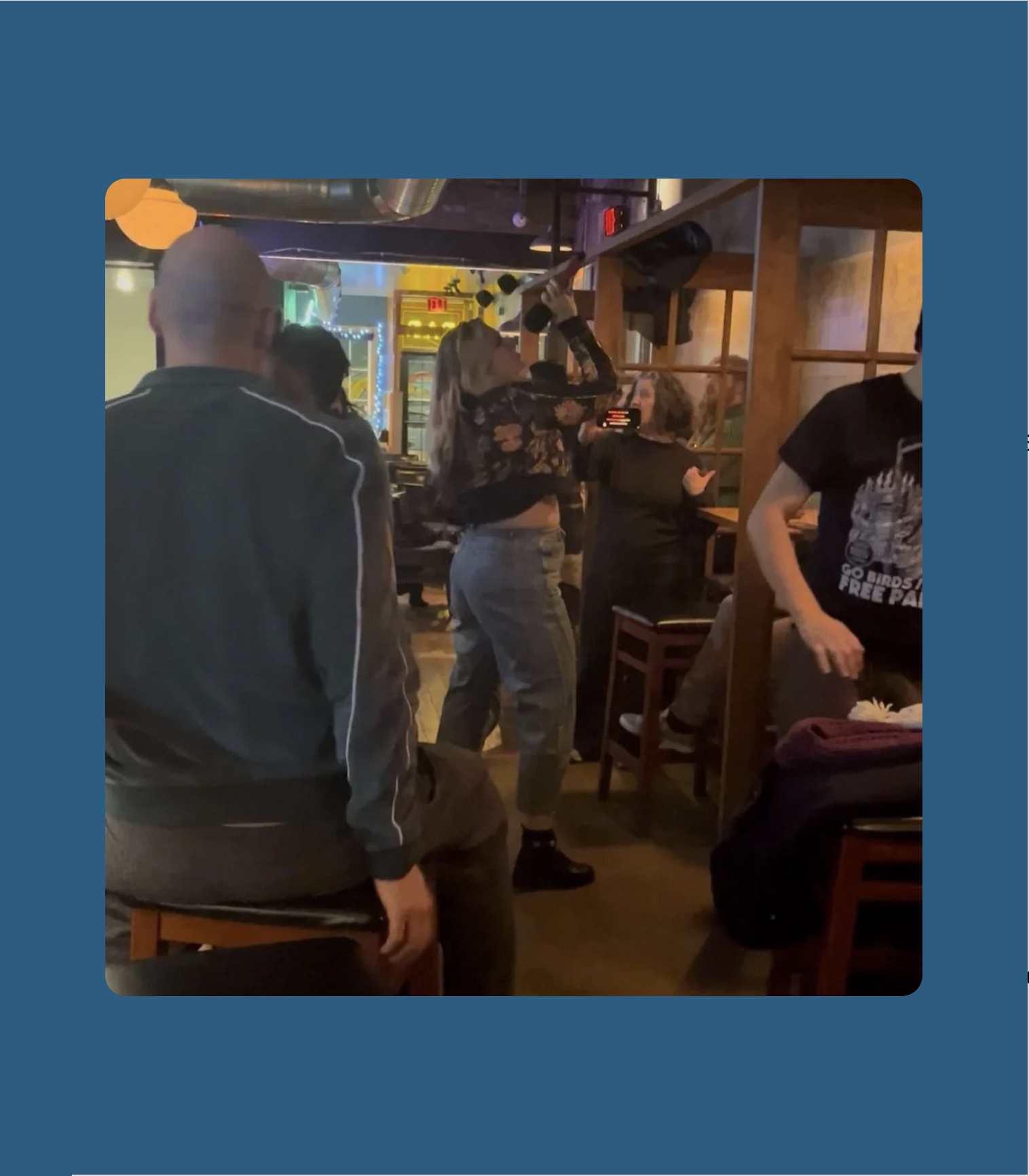 A woman belting out karaoke in a cozy bar.