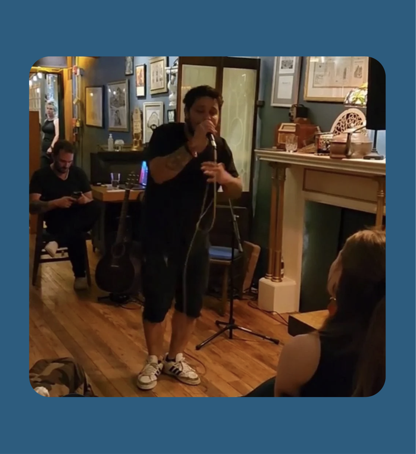 Man singing in front of excited crowd at open mic night