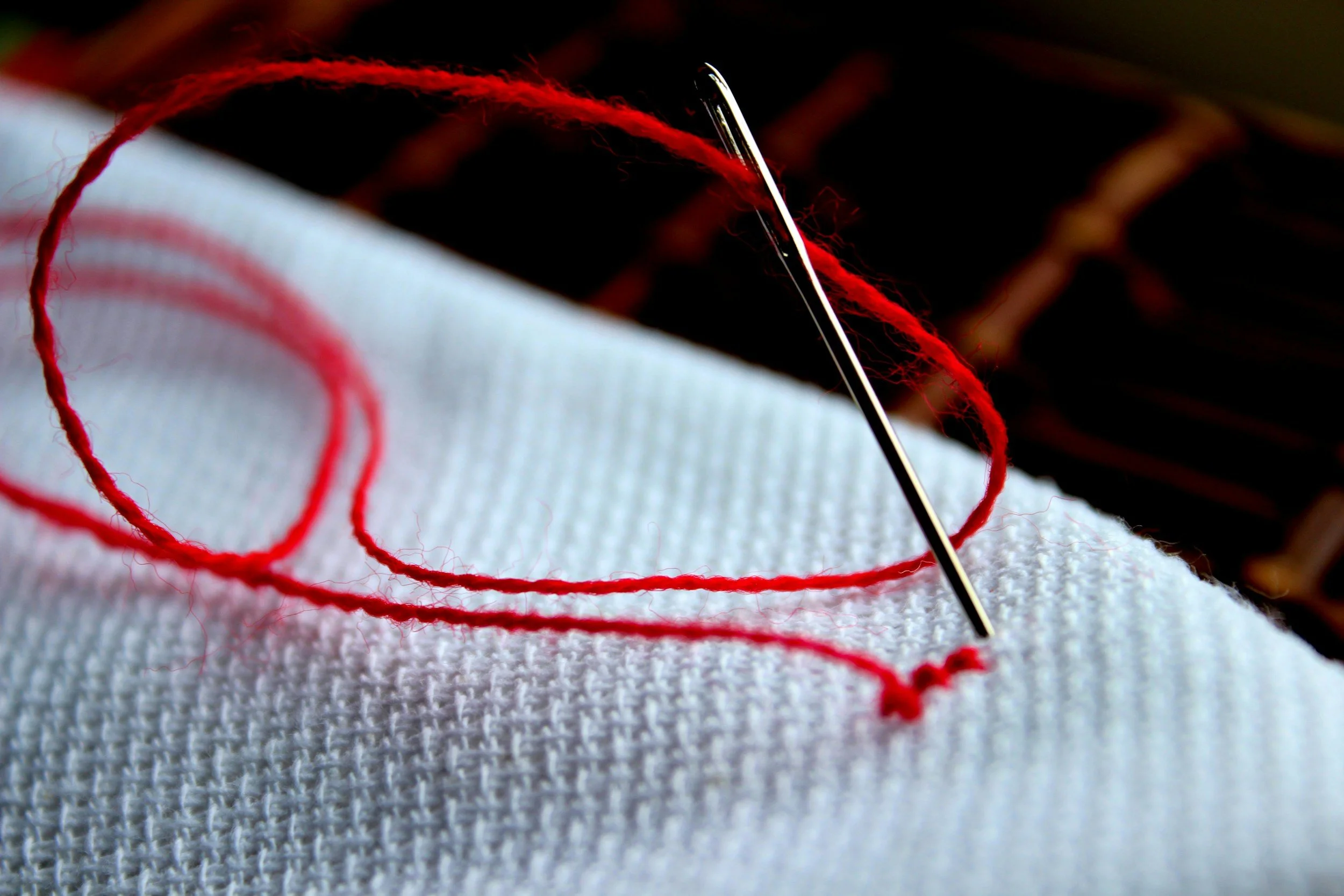 red thread stitched on white crossstitch material