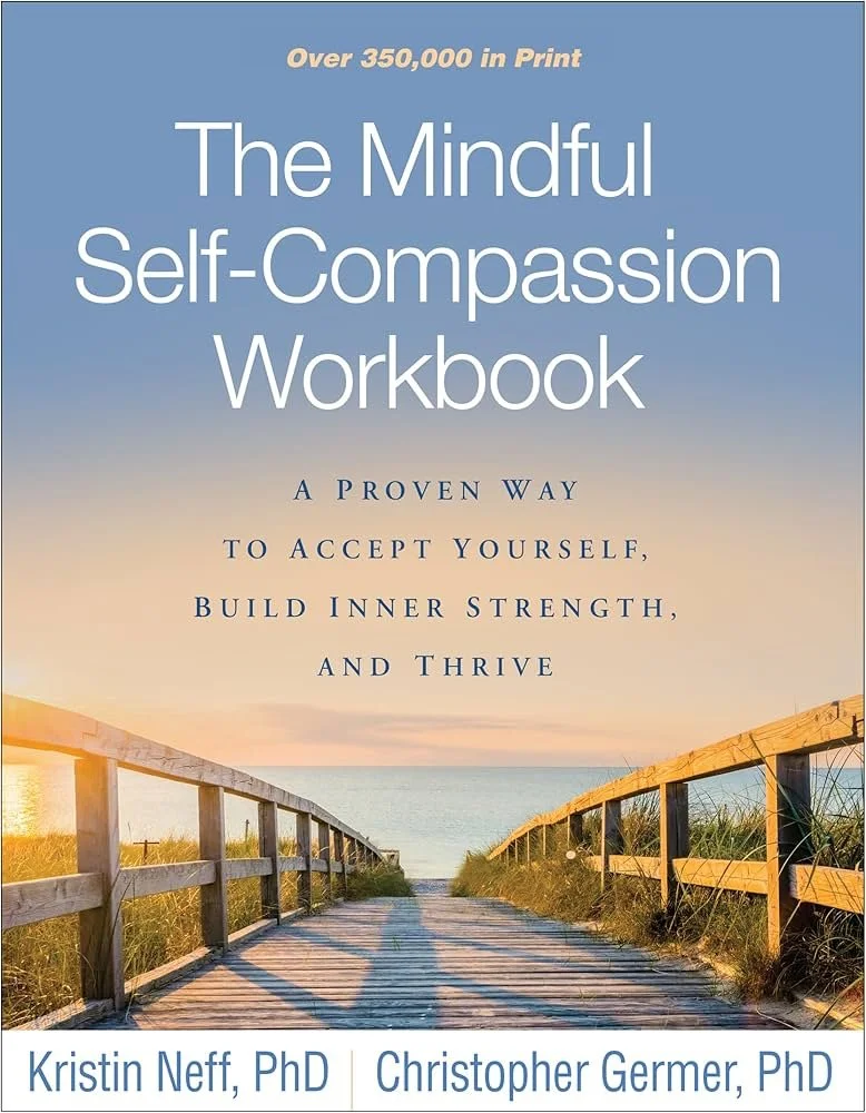 Book cover titled 'The Mindful Self-Compassion Workbook' with a subtitle about accepting oneself and building inner strength, featuring a wooden pathway leading to the beach at sunset, authored by Kristin Neff, PhD, and Christopher Germer, PhD.