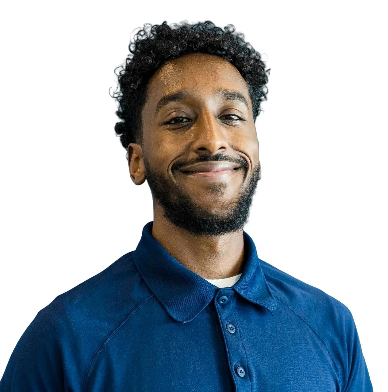 Smiling man with curly hair and a beard wearing a blue polo shirt against a white background.