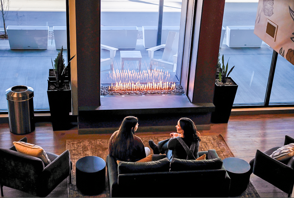 comfortable seating in front of a large glass fireplace