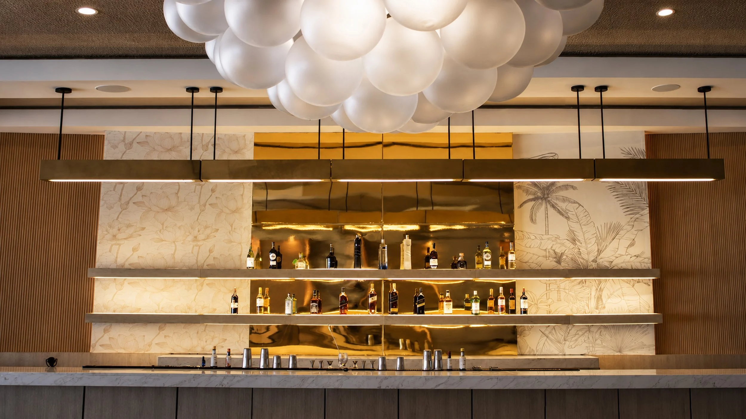 Bar con estanterías con botellas y una decoración moderna, luces y mobiliario sofisticado.