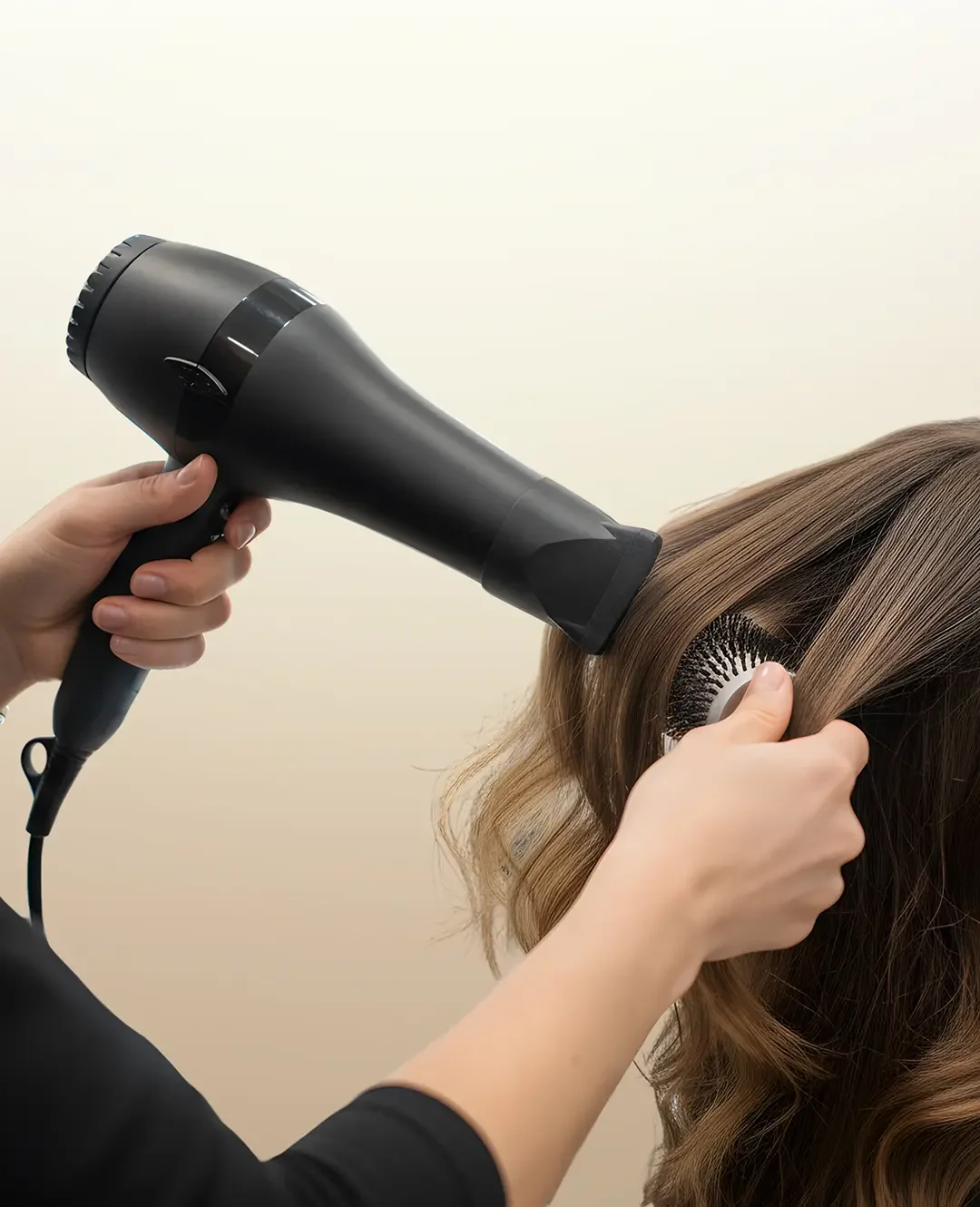 Stylist blow-drying client’s hair after keratin treatment application for smooth, frizz-free results.