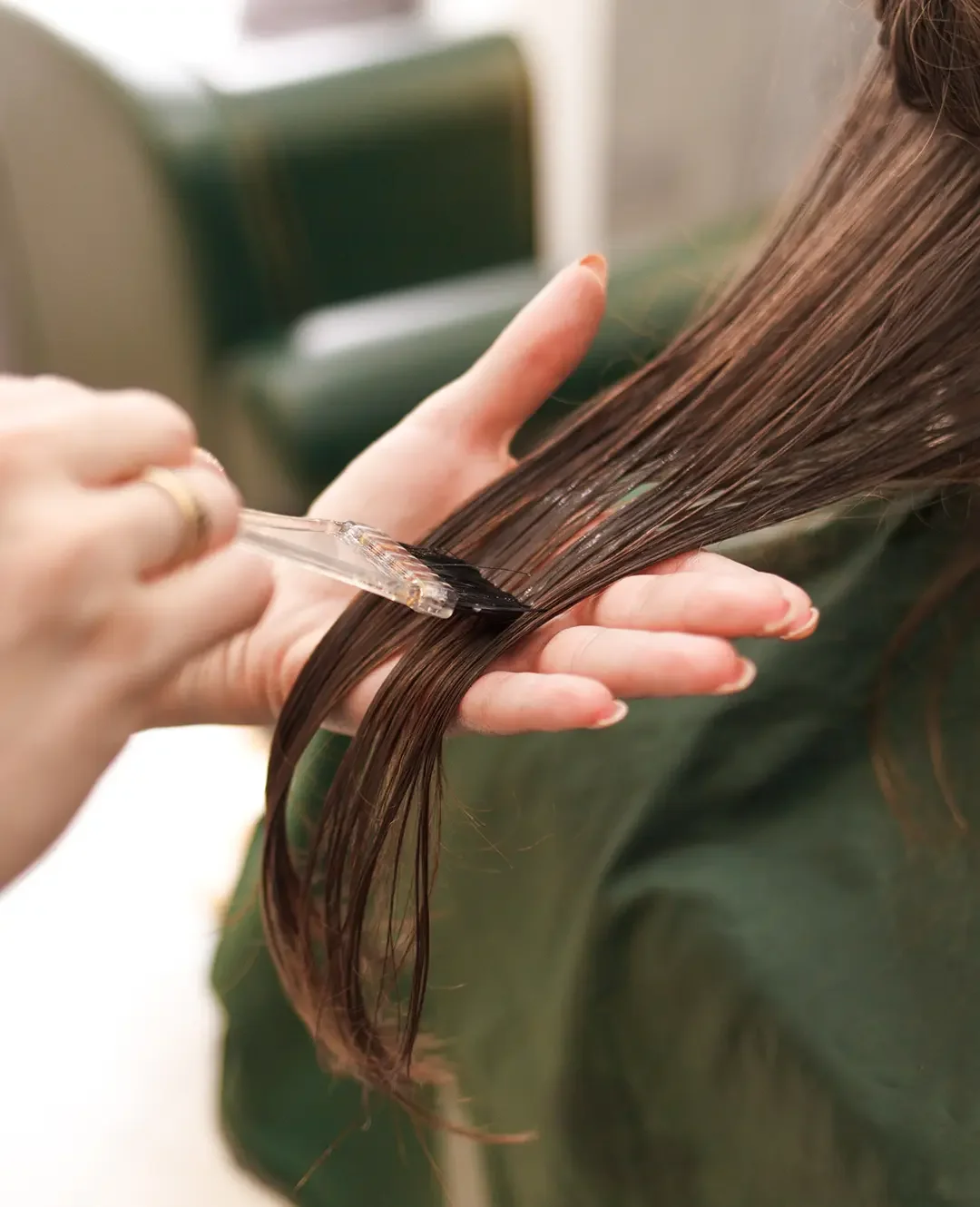 Stylist applying toner and gloss to refresh a client’s color and enhance dimension.