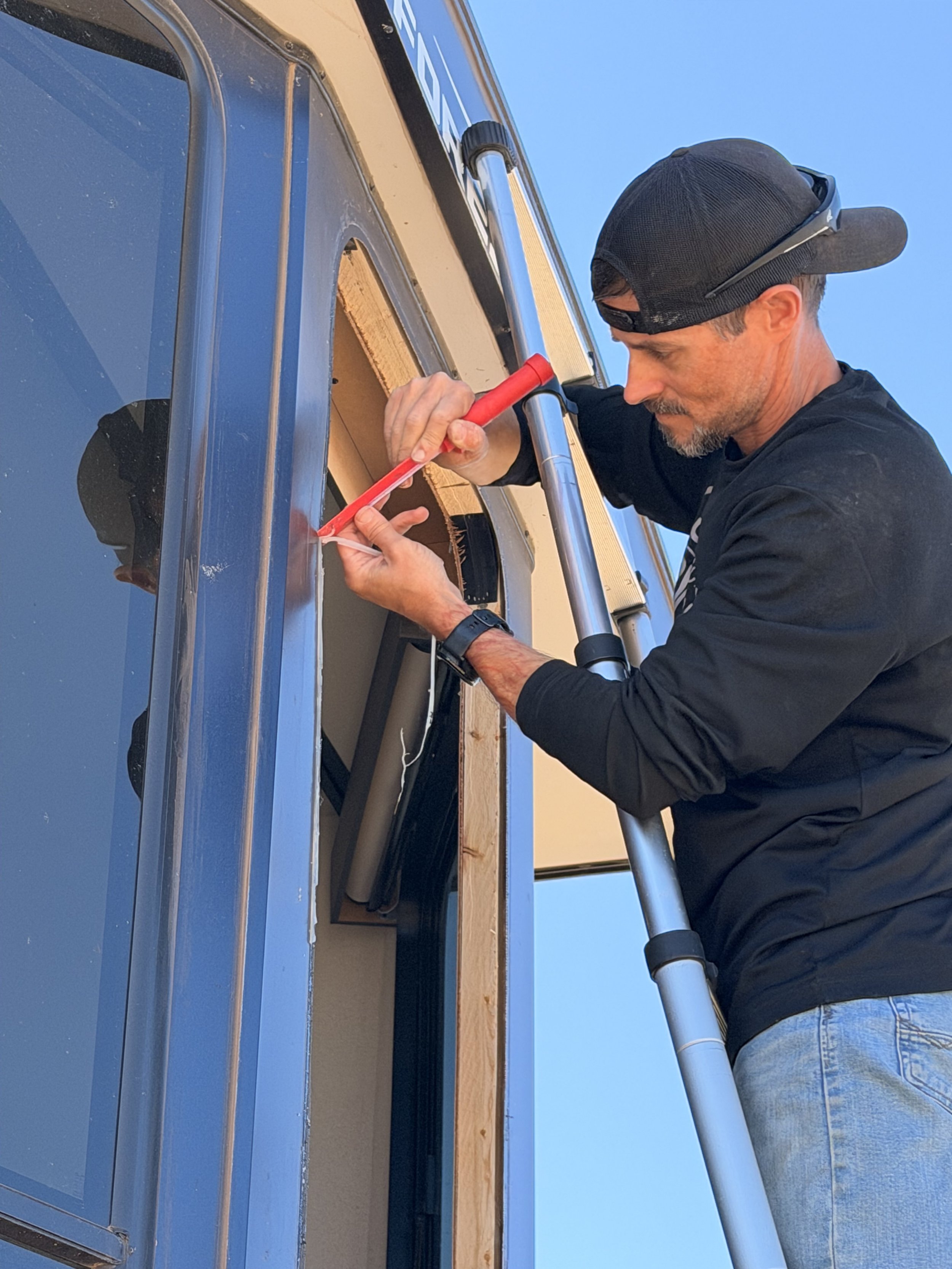Mobile RV Repair Tech removing and replacing broken RV Window