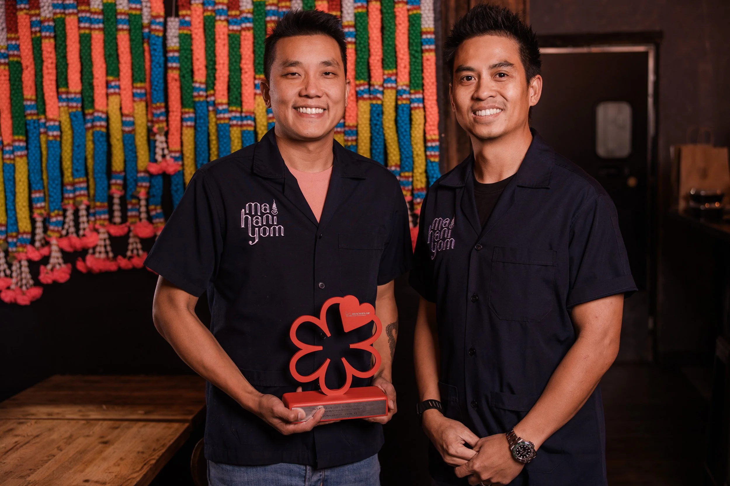 Mahaniyom Founders-Chompon Boong Boonnak and Smuch Top Saikamthorn holding Michelin Bib Gourmand Award