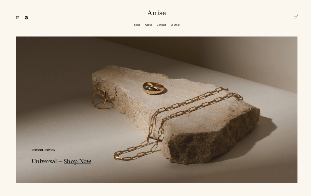 Jewelry display with a gold ring, gold chain necklace, and a gold ring on a piece of stone.