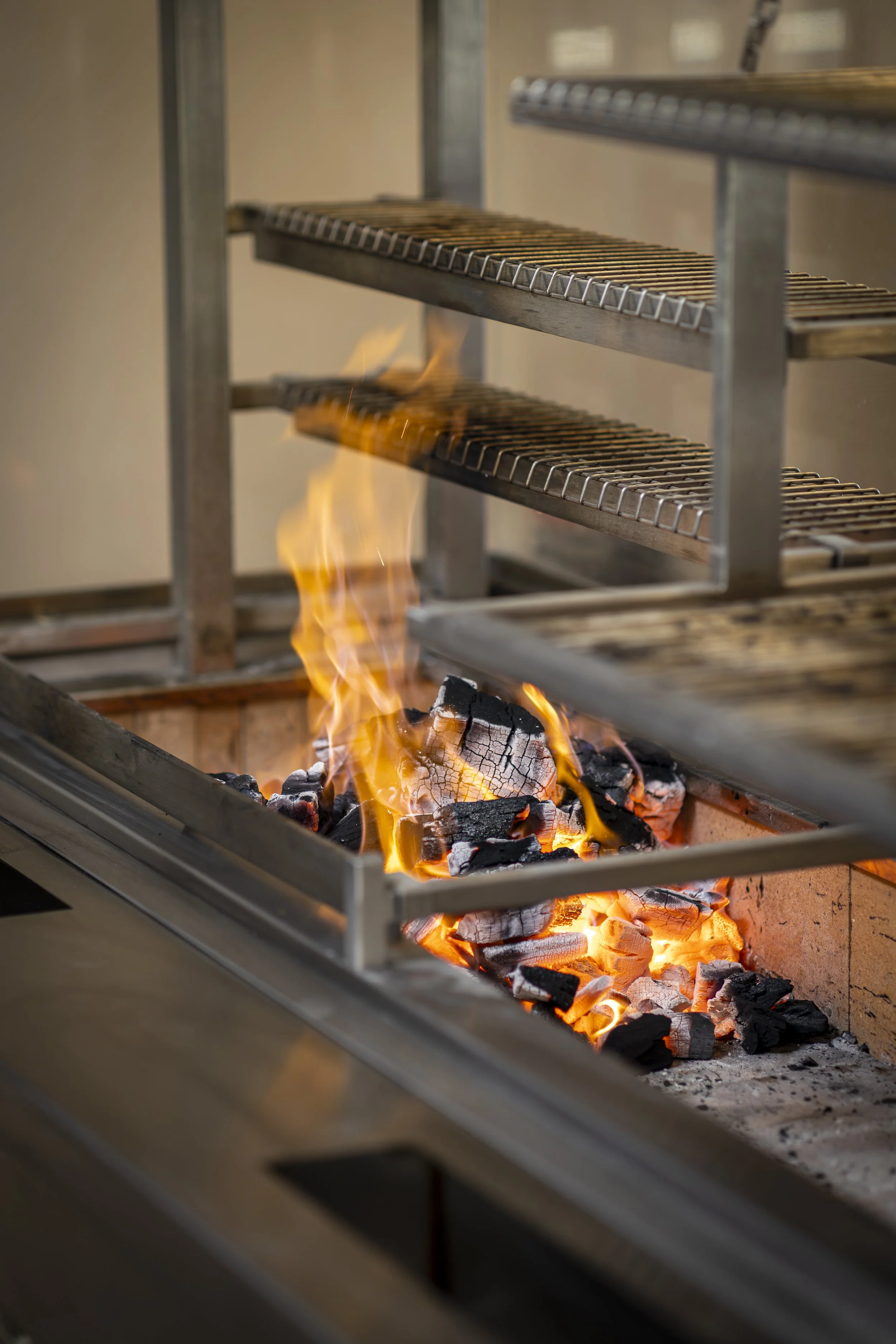 Open fire cooking, flames roaring over the grill for our guests to see.