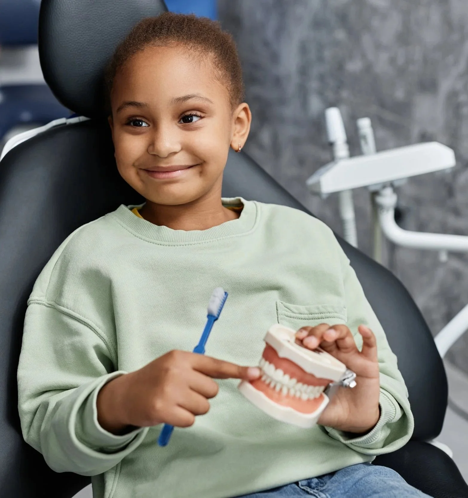 Young girl smiling in a dental chair receiving gentle hospital dentistry care