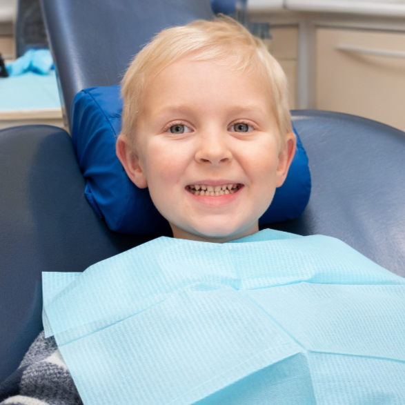 Child sitting comfortably in a dental chair during restorative pediatric dental treatment