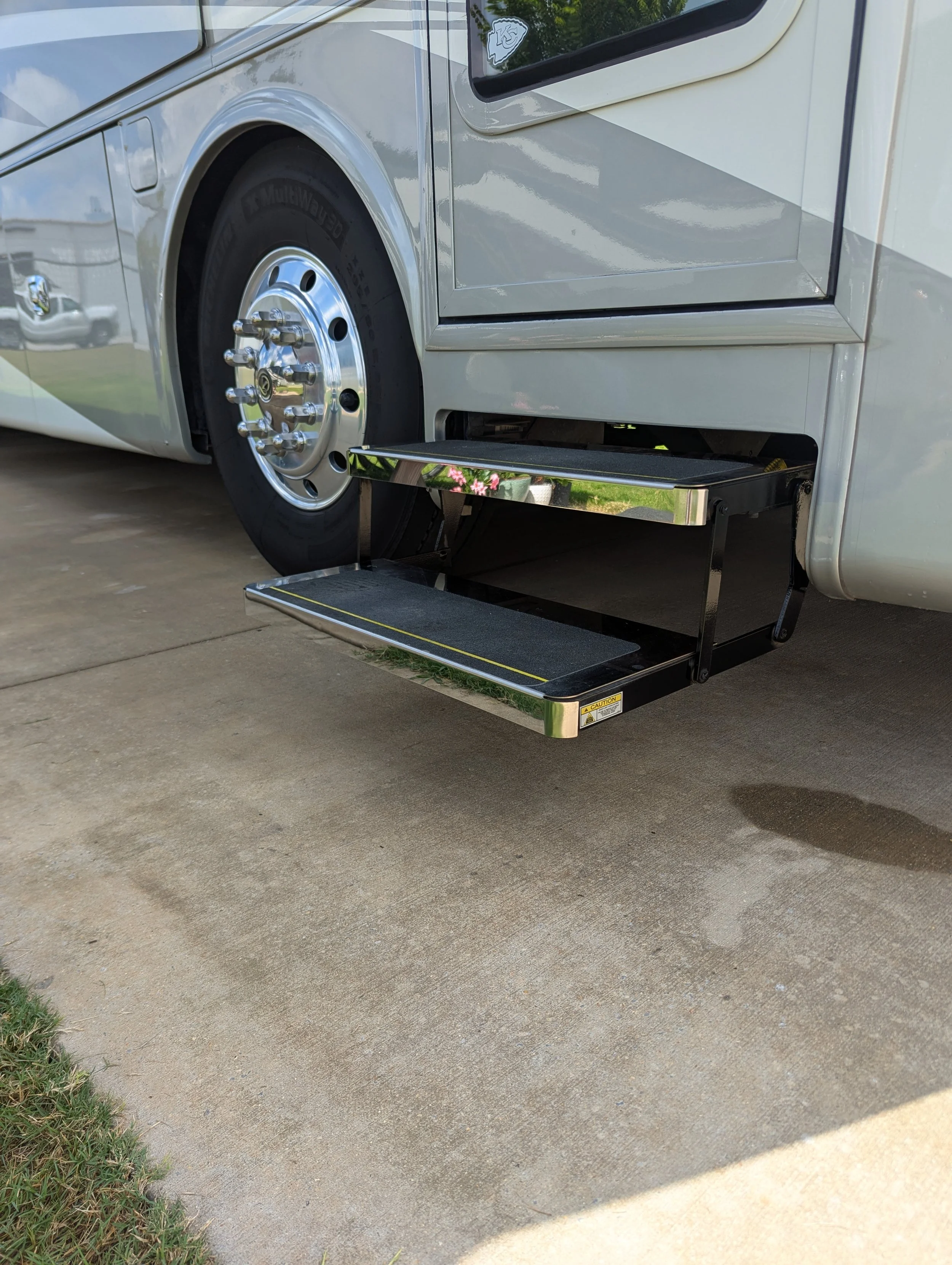 A step ladder attached to the side of a large white RV or bus.