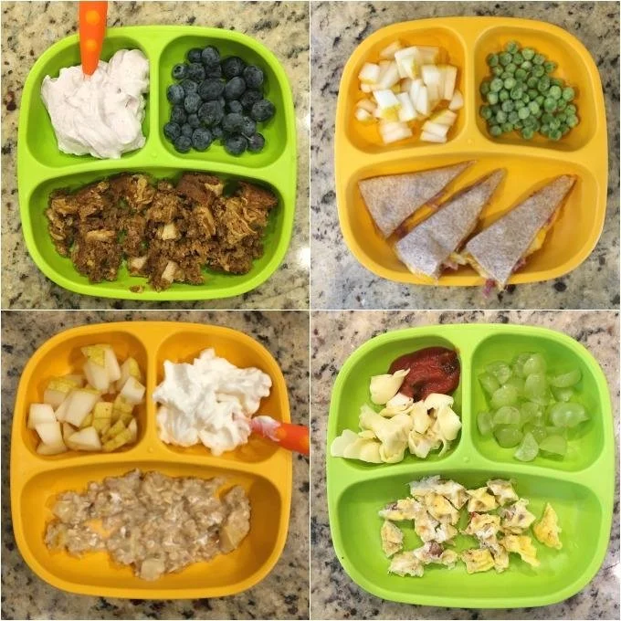 Four divided meal trays containing various foods. The green tray has whipped cream, blueberries, and shredded beef. The yellow tray has diced potatoes, green peas, and foil-wrapped sandwiches. The second yellow tray has diced potatoes, whipped cream,