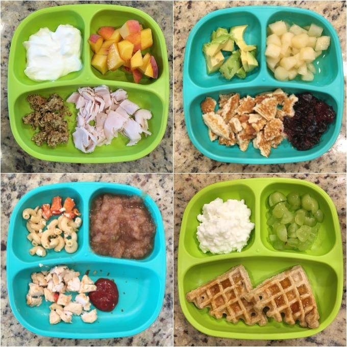 Four divided meal trays with various breakfast foods on a speckled countertop. Top left tray: yogurt, mixed fruit, granola, chicken pieces. Top right tray: chopped celery, melon chunks, cereal with milk, jam. Bottom left tray: pasta with vegetables, 