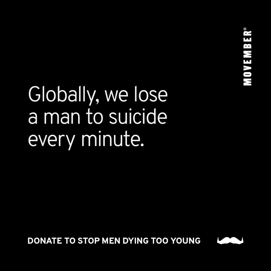 Black background flyer with white text stating, "Globally, we lose a man to suicide every minute." A small white mustache icon is at the bottom right, with encouraging message "Donate to stop men dying too young." The word "November" appears vertical